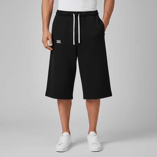 Model wearing black SOL Coastline Cropped Sweatpants, with white drawstrings and small white thigh logo.