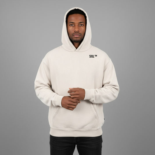 Adult model wearing the Mild Apricot SOL Glacier Oversized Hoodie, with hood up and small chest logo visible.