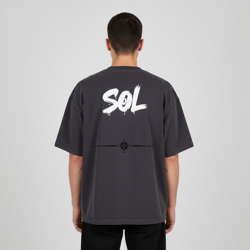 Model wearing black SOL Relic Boxy Tee, rear view showing white SOL artwork and decorative back graphic
