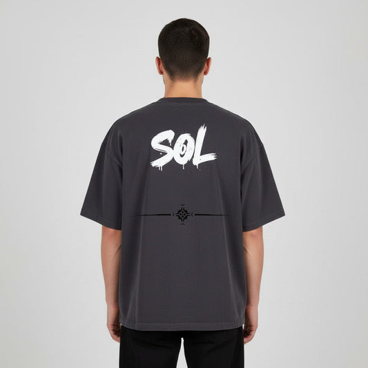 Model wearing black SOL Relic Boxy Tee, rear view showing white SOL artwork and decorative back graphic