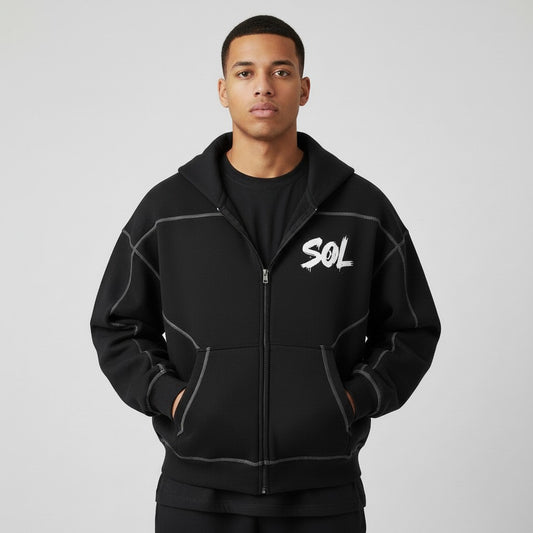 Model wearing the black SOL Seamwork Contrast Zip Hoodie with white chest graphic and contrast seams