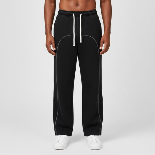 Model wearing black SOL Seamwork Fleece Sweatpants with white drawstrings and curved contrast seams